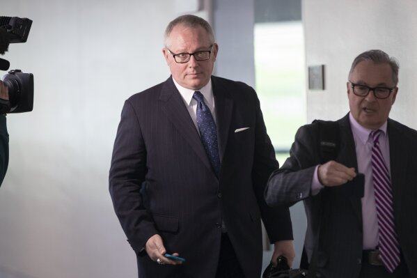 FILE - In this May 1, 2018, file photo, Former Donald Trump campaign official Michael Caputo, left, joined by his attorney Dennis C. Vacco, leaves after being interviewed by Senate Intelligence Committee staff investigating Russian meddling in the 2016 presidential election, on Capitol Hill in Washington. A House subcommittee examining President Donald Trump’s response to the coronavirus pandemic is launching an investigation into reports that political appointees have meddled with routine government scientific data to better align with Trump’s public statements. The Democrat-led subcommittee said Sept. 14, 2020 that it is requesting transcribed interviews with seven officials from the Centers for Disease Control and Prevention and the Department of Health and Human Services, including communications aide Michael Caputo. (AP Photo/J. Scott Applewhite, File)