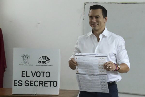 President Daniel Noboa holds the ballot during a referendum to endorse new security measures to crackdown on criminal gangs responsible for increasing violence, in Olon, Ecuador, Sunday, April 21, 2024. (AP Photo/Cesar Munoz)