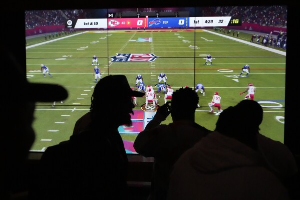 People play EA Sports' Madden NFL video game on a projection screen at Interscope Records Studios In Santa Monica, Calif., Wednesday, June 21, 2023. The NFL, Interscope Geffen A&M Records and Electronic Arts Sports have partnered to empower NFL players to pursue their passion of music and create the extended play project "Crowd Control," which was released Tuesday. (AP Photo/Damian Dovarganes)