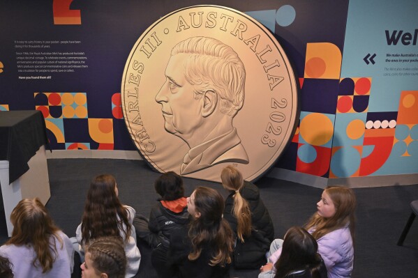 School children look at a large mock up of a new coin at The Royal Australian Mint in Canberra, Thursday, Oct. 5, 2023. An image of King Charles III will soon appear on Australian coins more than a year after the death of his mother Queen Elizabeth II, officials said. (Mick Tsikas/AAP Image via AP)