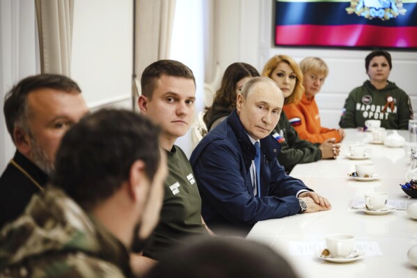 In this photo released by the Russian Presidential Press Service on Wednesday, May 21, 2025, Russian President Vladimir Putin, center, speaks with volunteers at Kursk region, Russia. (Russian Presidential Press Service via AP)