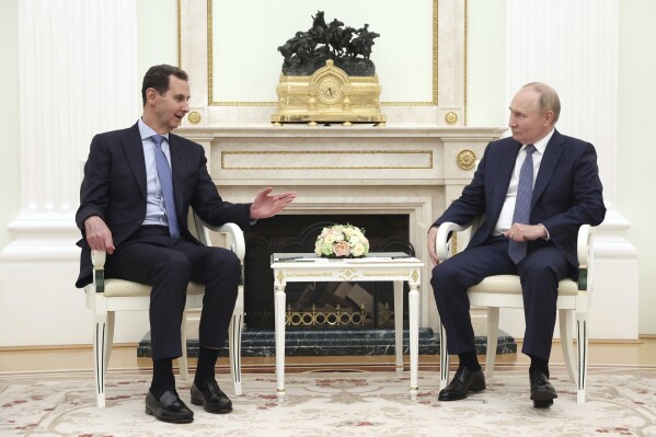 Syrian President Bashar Assad, left, speaks with Russian President Vladimir Putin during their meeting in Moscow, Russia, Wednesday, July 24, 2024. (Valery Sharifulin, Sputnik, Kremlin Pool Photo via ĢӰԺ)