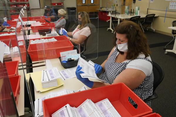 FILE — Election workers inspect ballots that have been received for the Sept. 14, recall election, for damage at the Sacramento County Registrar of Voters office in Sacramento, Calif., Aug. 30, 2021. This week’s gripping testimony about threats to election officials by former President Donald Trump and his followers had a rapt audience outside Washington -- secretaries of state and election clerks across the country who said the stories could very well have been their own.  (AP Photo/Rich Pedroncelli, File)