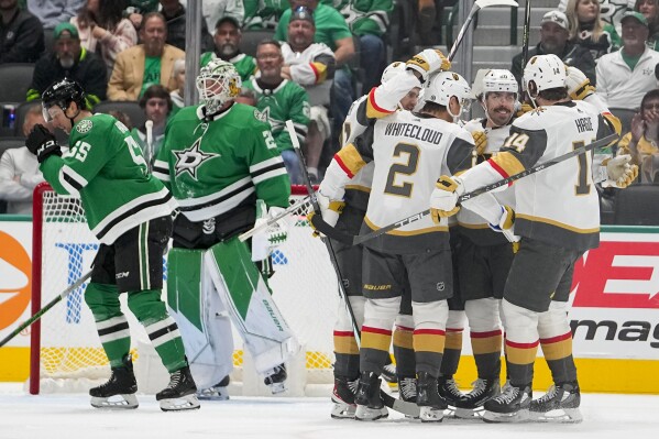 Vegas Golden Knights center Chandler Stephenson, second from right, celebrates his first period goal with teammates after scoring on Dallas Stars goaltender Jake Oettinger, second from left, during an NHL hockey game, Saturday, Dec. 9, 2023, in Dallas. (AP Photo/Julio Cortez)