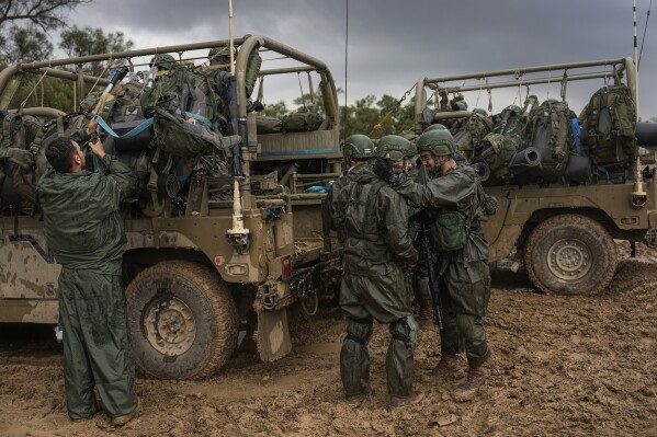 Israeli soldiers prepare to enter the Gaza Strip, at a staging area near the Israeli-Gaza border, in southern Israel, Wednesday, Dec. 13, 2023. The army is battling Palestinian militants across Gaza in the war ignited by Hamas' Oct. 7 attack into Israel. (AP Photo/Ohad Zwigenberg)