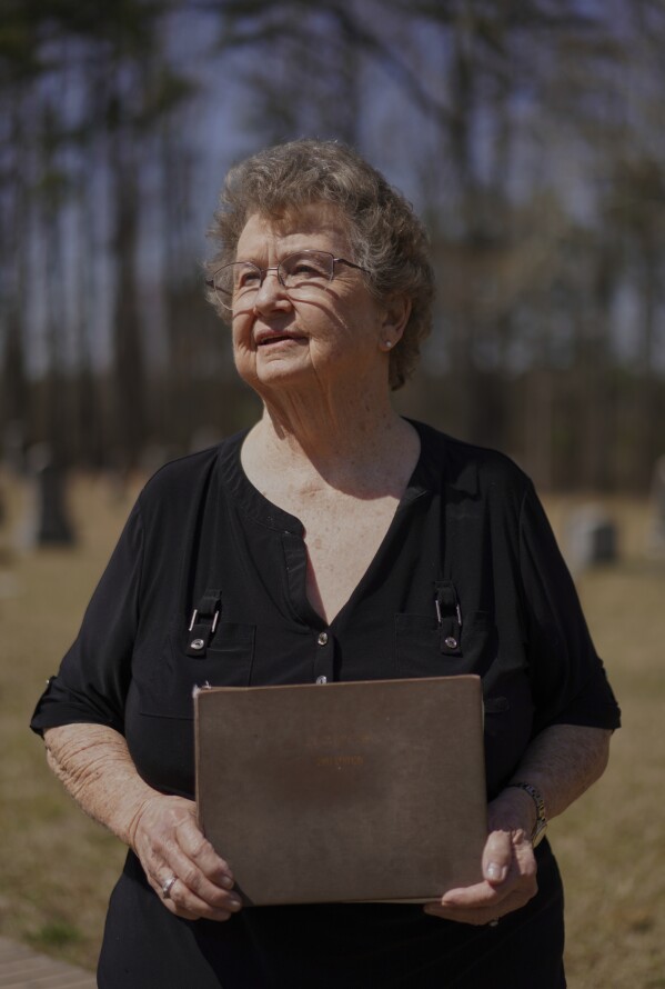 Reba Dell Windom, a longtime Sacred Harp singer poses for a portrait with her worn 1991 edition at Holly Springs Primitive Baptist Church in Bremen, Ga., on Sunday, March 23, 2025. (AP Photo/Jessie Wardarski)