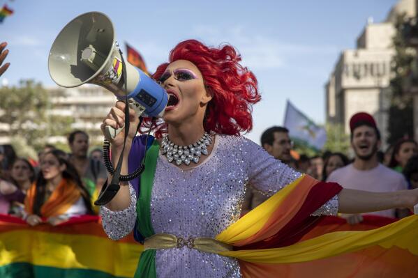 A participant dances in the annual Gay Pride parade in Jerusalem, Thursday, June 3, 2021. Thousands of people marched through the streets of Jerusalem on Thursday in the city's annual gay pride parade. (AP Photo/Ariel Schalit)