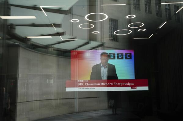 A screen showing a news report through the windows of the BBC, after chairman Richard Sharp announced he was quitting as BBC chairman, in London, Friday April 28, 2023. The chairman of the BBC has resigned after a report found he breached the government rules governing public appointments. The publicly funded national broadcaster has been under pressure after it was revealed that Sharp, a Conservative Party donor helped arrange a loan for then-Prime Minister Boris Johnson in 2021, weeks before he was appointed to the BBC post on the government’s recommendation. (Jordan Pettitt/PA via AP)