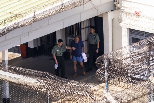 FILE - Jimmy Lai, center, exits his building to go for exercise at the Stanley prison in Hong Kong, Friday, Aug. 4, 2023. The son of jailed Hong Kong media mogul and prominent pro-democracy activist Lai said Wednesday, Sept. 20, he did not want to see his father die in detention, as his lawyers raised the prospect that his long-delayed trial may be pushed back indefinitely. (AP Photo/Louise Delmotte, File)