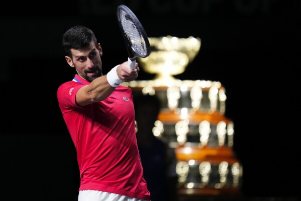 Serbia's Novak Djokovic reacts, with the Davis Cup on the background, during a Davis Cup quarter-final tennis match against Britain's Cameron Norrie in Malaga, Spain, Thursday, Nov. 23, 2023. (AP Photo/Manu Fernandez)