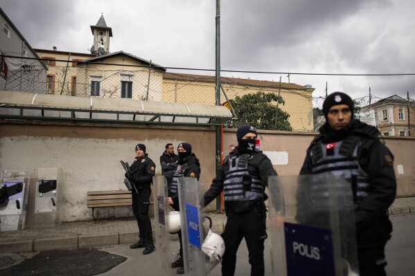 Turkish police officers stand guard in a cordoned off area outside the Santa Maria church, in Istanbul, Turkey, Sunday, Jan. 28, 2024. Two masked assailants attacked a church in Istanbul during Sunday services, killing one person, Turkish officials said. (AP Photo/Emrah Gurel)