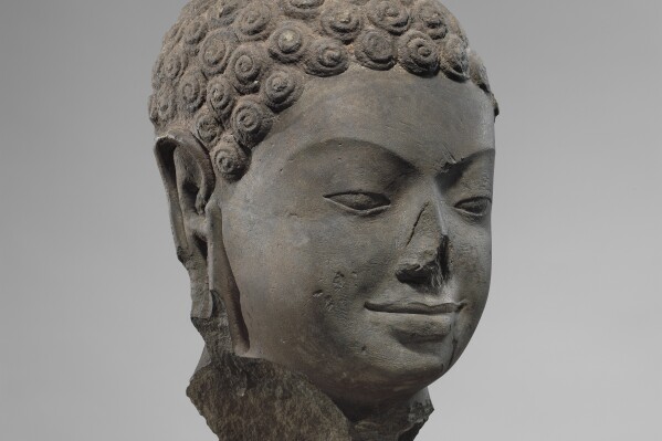 This December 2005 photo shows a 7th century sculpture titled "Head of Buddha" at the Metropolitan Museum of Art in New York. The sculpture is one of 16 pieces of artwork that the museum said it will return to Cambodia and Thailand that federal prosecutors say were tied to an art dealer and collector accused of running a huge antiquities trafficking network out of Southeast Asia. (Metropolitan Museum of Art via AP)