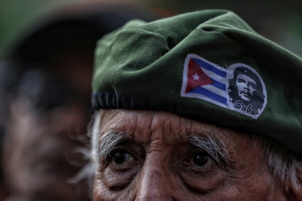 Un hombre, que porta una boina con una bandera cubana y la imagen de Ernesto 