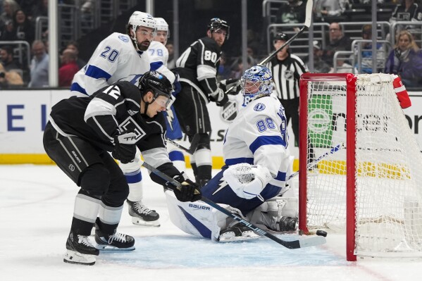 Los Angeles Kings' Trevor Moore (12) scores against Tampa Bay Lightning goaltender Andrei Vasilevskiy (88) during the second period of an NHL hockey game Saturday, March 23, 2024, in Los Angeles. (AP Photo/Jae C. Hong)