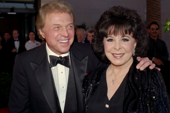 FILE - Singer Steve Lawrence, left, and his wife Eydie Gorme arrive at a black-tie gala called honoring Frank Sinatra in Las Vegas on May 30, 1998. Lawrence, a singer and top stage act who as a solo performer and in tandem with his wife Gorme kept Tin Pan Alley alive during the rock era, died Wednesday, March 6, 2024 at age 88. Gorme died on Aug. 10, 2013. (AP Photo/Lennox McLendon, File)