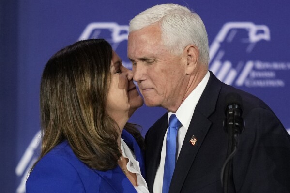 Karen Pence, left, kisses former Vice President Mike Pence at an annual leadership meeting of the Republican Jewish Coalition, Saturday, Oct. 28, 2023, in Las Vegas. Pence is dropping his bid for the Republican presidential nomination, ending his campaign for the White House. He said in Las Vegas that "after much prayer and deliberation, I have decided to suspend my campaign for president effective today." (AP Photo/John Locher)