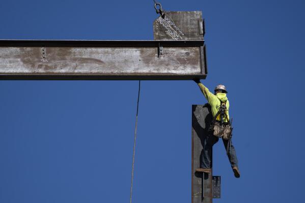An ironworker guides a beam during construction of a municipal building in Norristown, Pa., Wednesday, Feb. 15, 2023. The strength of the American job market has consistently defied expectations throughout the economic tumult of the COVID years. (AP Photo/Matt Rourke)