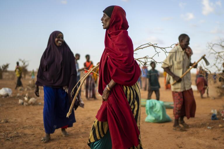 A woman builds shelter at a camp for displaced people on the outskirts of Dollow, Somalia, on Monday, Sept. 19, 2022.  Somalia is in the midst of the worst drought anyone there can remember. A rare famine declaration could be made within weeks. Climate change and fallout from the war in Ukraine are in part to blame. (AP Photo/Jerome Delay)