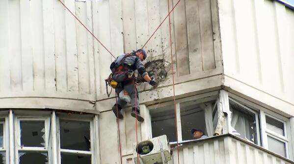 In this image taken from video, investigators inspect the building after a Ukrainian drone damaged an apartment building in Moscow, Russia, Tuesday, May 30, 2023. In Moscow, residents reported hearing explosions and Mayor Sergei Sobyanin later confirmed there had been a drone attack that he said caused "insignificant" damage. (AP Photo)