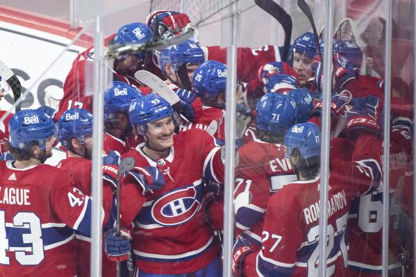 Players from the Montreal Canadiens celebrate a goal by teammate Cole Caufield (22) against the St. Louis Blues during overtime period NHL hockey game action in Montreal, Thursday, Feb. 17, 2022. (Graham Hughes/The Canadian Press via AP)