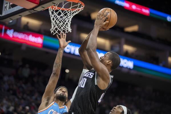 Sacramento Kings forward Harrison Barnes (40) scores a basket in front of Los Angeles Clippers guard Paul George, left, during the first quarter of an NBA basketball game in Sacramento, Calif., Wednesday, Dec. 22, 2021. (AP Photo/José luis Villegas)