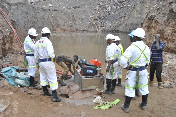 Mine workers are seen during a rescue mission in Chingola, around 400 kilometres (248 miles) north of the capital Lusaka, Zambia, Saturday, Dec. 2, 2023. Seven miners were confirmed dead and more than 20 others were missing and presumed dead after heavy rains caused landslides that buried them inside tunnels they had been digging illegally at a copper mine in Zambia, police and local authorities said Saturday. (AP Photo)