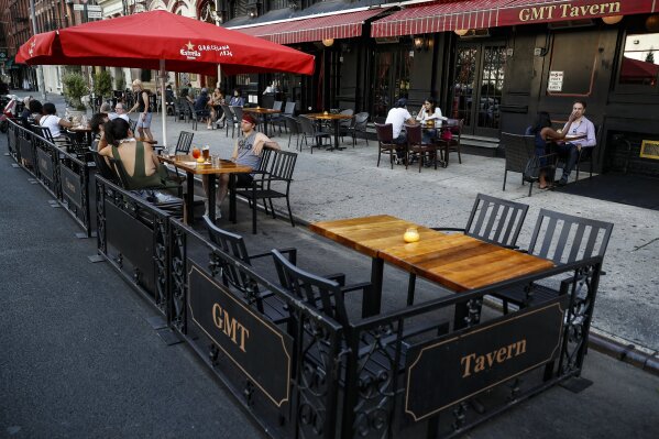 Customers dine outside GMT Tavern, Monday, June 22, 2020, in New York. New York City Mayor Bill de Blasio says he is delaying the planned resumption of indoor dining at restaurants in the city out of fear it would ignite a a spike in coronavirus infections. (AP Photo/John Minchillo)