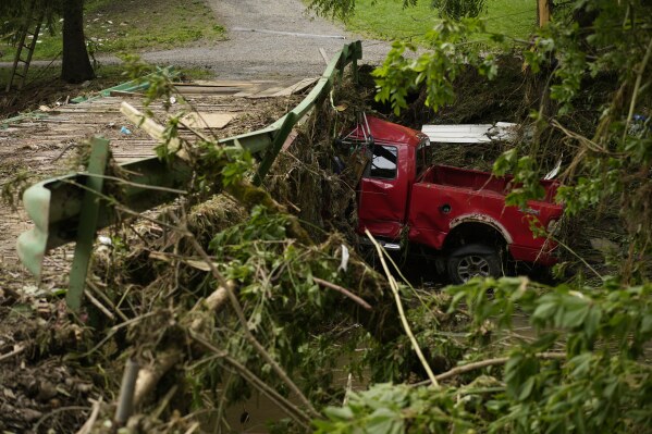 A vehicle sits in flood debris, Monday, June 16, 2025, in Valley Grove, W.Va. (AP Photo/Carolyn Kaster)