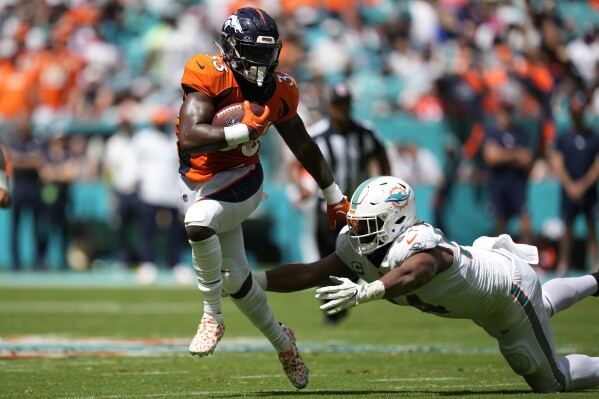 Miami Dolphins defensive tackle Christian Wilkins (94) goes after Denver Broncos quarterback Russell Wilson (3) during the first half of an NFL football game, Sunday, Sept. 24, 2023, in Miami Gardens, Fla. (AP Photo/Rebecca Blackwell)