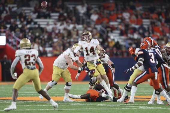 Boston College quarterback Emmett Morehead (14) throws an incomplete pass as he's hit by Syracuse defensive lineman Cody Roscoe during the second half of an NCAA college football game in Syracuse, N.Y., Saturday, Oct. 30, 2021. (AP Photo/Joshua Bessex)