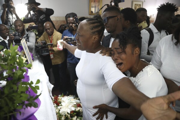 Relatives cry by the coffin of journalist Jimmy Jean, who was killed during an armed gang attack on the General Hospital, during his church funeral service in the Petion-Ville neighborhood of Port-au-Prince, Haiti, Thursday, Jan. 16, 2025. (AP Photo/Odelyn Joseph)