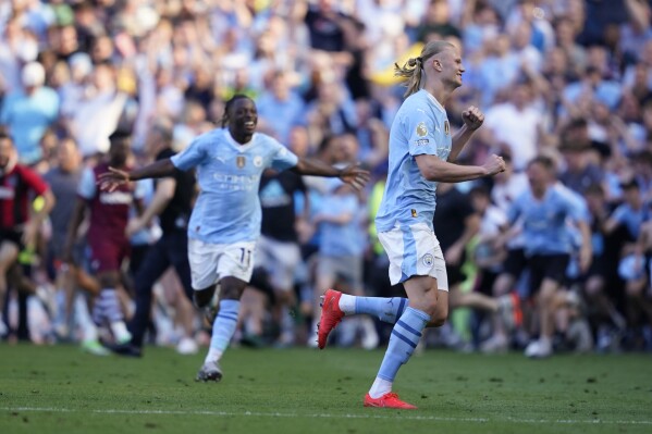 Manchester City's Erling Haaland, right, and Manchester City's Jeremy Doku celebrate at the end of the English Premier League soccer match between Manchester City and West Ham United at the Etihad Stadium in Manchester, England, Sunday, May 19, 2024. Manchester City clinched the English Premier League on Sunday after beating West Ham in their last match of the season. (AP Photo/Dave Thompson)