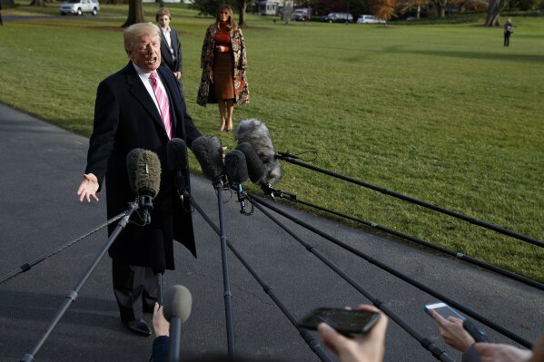 
              President Donald Trump speaks to reporters before leaving the White House, Tuesday, Nov. 21, 2017, in Washington for a Thanksgiving trip to Mar-a-Lago estate in Palm Beach, Fla., as first lady Melania Trump and their son Barron wait. (AP Photo/Evan Vucci)
            