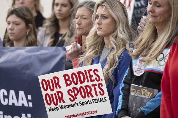 FILE - Former University of Kentucky swimmer Riley Gaines, second from right, stands during a rally on Thursday, Jan. 12, 2023, outside of the NCAA Convention in San Antonio. Gaines was among more than a dozen college athletes who filed a lawsuit against the NCAA on Thursday, March 14, 2023, accusing it of violating their Title IX rights by allowing Lia Thomas to compete at national championships in 2022. (AP Photo/Darren Abate, File)