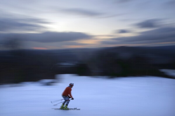 FILE - A skier descends Black Mountain of Maine, Feb. 11, 2023, in Rumford, Maine. A new study says U.S. ski areas lost about $5 billion from 2000 to 2019 as a result of human-caused climate change. (AP Photo/Robert F. Bukaty, File)