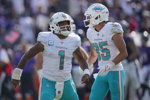 Miami Dolphins quarterback Tua Tagovailoa (1) and wide receiver River Cracraft (85) celebrate a touchdown during the second half of an NFL football game against the Baltimore Ravens, Sunday, Sept. 18, 2022, in Baltimore. (AP Photo/Julio Cortez)
