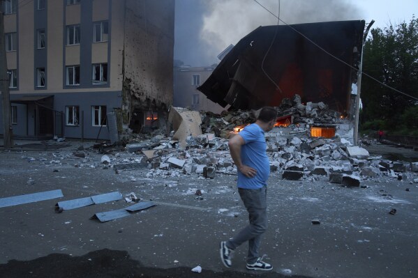 Residents respond as he passes by as he burns out following the attack of Russian missiles and drones in Kiev, Ukraine on Tuesday, June 10, 2025.