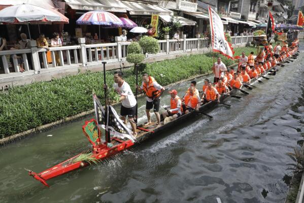 Dragon boat participants from Panting village row along a canal in the historic Lychee Bay scenic area in Guangzhou in southern China's Guangdong Province, Friday, June 3, 2022. Dragon boat races returned in parts of China on Friday for the first time since the outbreak of the pandemic in late 2019, as restrictions are lifted along with a major drop in COVID-19 cases. (AP Photo/Caroline Chen)