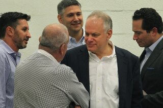 
              In this Dec. 20, 2016 photo, Stephen Bittel, center, chats with voters as members of the Miami-Dade Democratic Party Executive Committee meet in Wynwood, Fla., to elect a new state committeeman. Florida Democratic Party Chairman Bittel has been accused of sexually inappropriate comments and behavior toward a number of women and has resigned. (Patrick Farrell /Miami Herald via AP)
            