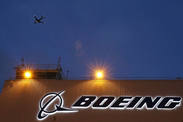 FILE - An airplane flies over a sign on Boeing's 737 delivery center, Oct. 19, 2015, at Boeing Field in Seattle. The Federal Aviation Administration says a Southwest Airlines jet leaving Denver was forced to land after the engine cover fell off and struck the wing flap during takeoff. Southwest Airlines says the Boeing 737 landed safely Sunday, April 7, 2024, and the passengers headed to Houston are being put onto another aircraft. (AP Photo/Ted S. Warren, File)