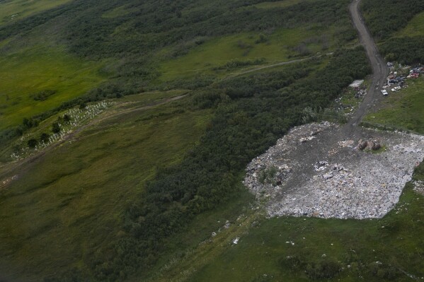 The village landfill site, sits near the Akiachak cemetery, Wednesday, Aug. 16, 2023, in Akiachak, Alaska. Garbage, scrap metal, and human waste is dumped in the plot of land half a mile away from the village. (AP Photo/Tom Brenner)