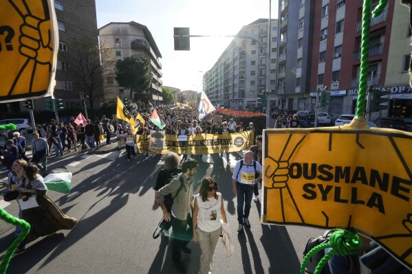 Demonstrators hold signs with the name of Ousmane Sylla, as they ask for the closure of all the facilities created in Italy to detain migrants in Milan. (AP Photo/Luca Bruno)