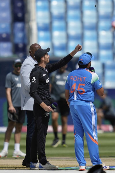 India's captain Rohit Sharma, right, watches as New Zealand's captain Mitch Santner flips the coin at the toss ahead of the ICC Champions Trophy cricket match between India and New Zealand at Dubai International Cricket Stadium in Dubai, United Arab Emirates, Sunday, March 2, 2025. (AP Photo/Altaf Qadri)