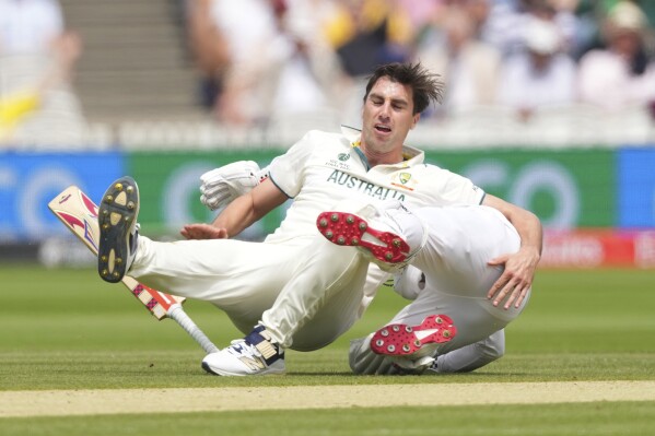 Australia's captain Pat Cummins, left, falls after a collision with South Africa's Kyle Verreynne while appealing for Verreynne's wicket on day two of the World Test Championship final between South Africa and Australia at Lord's cricket ground in London, Thursday, June 12, 2025. (AP Photo/Kirsty Wigglesworth)