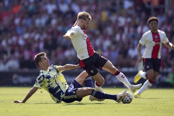 Leeds United's Diego Llorente tackles Southampton's Stuart Armstrong during the English Premier League soccer match between Leeds United and Southampton at St. Mary's Stadium, Southampton, England, Saturday Aug. 13, 2022. (Adam Davy/PA via AP)