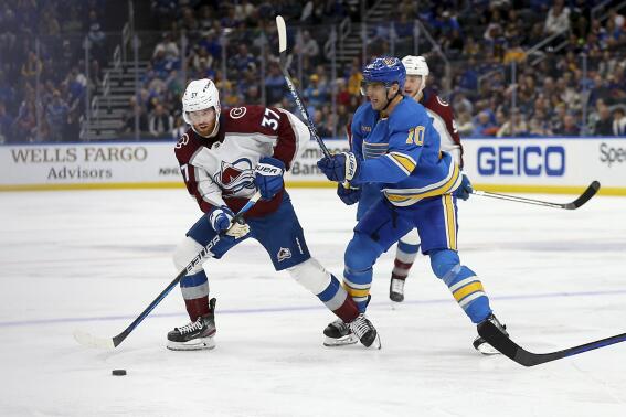 Colorado Avalanche's J.T. Compher (37) looks to pass the puck while under pressure from St. Louis Blues' Brayden Schenn (10) during the third period of an NHL hockey game Saturday, Feb. 18, 2023, in St. Louis. (AP Photo/Scott Kane)