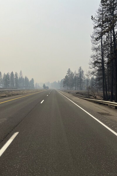 FILE - In this photo provided by WSDOT East (Washington State of Transportation), smoke from wildfires fill the sky at Salnave/SR 902 interchange in Spokane County, Wash., on Saturday, Aug. 19, 2023. Authorities say a second person has died in wildfires in eastern Washington state that sparked Friday, burning hundreds of structures and closing a section of a major interstate. Fire officials said Monday, Aug. 21, a body was found in the area of the Oregon fire north of Spokane on Sunday. (WSDOT East via AP, File)