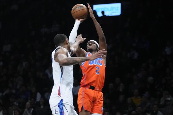 Oklahoma City Thunder's Shai Gilgeous-Alexander (2) shoots over Brooklyn Nets' Nic Claxton during the second half of an NBA basketball game Sunday, Jan. 15, 2023 in New York. (AP Photo/Frank Franklin II)