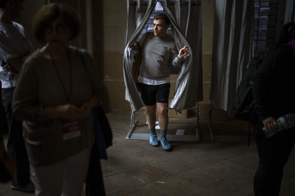 A man holds a ballot paper after voting during Catalonia's regional elections at a polling station, in Barcelona, Sunday, May 12, 2024. Catalonia is holding a regional election whose outcome will reverberate in Spain’s national politics. (AP Photo/Emilio Morenatti)