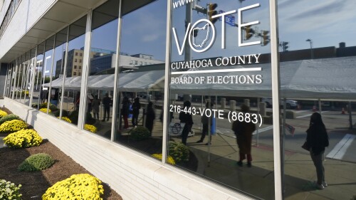 FILE - Voters are reflected in a window as they wait in line to participate in early voting at the Cuyahoga County Board of Elections in Cleveland, Oct. 6, 2020. Voter registration closes Monday, July 10, 2023, in Ohio for a high-stakes Aug. 8 election on whether to make it tougher to amend the state constitution. Early in-person voting starts July 11. (AP Photo/Tony Dejak, File)